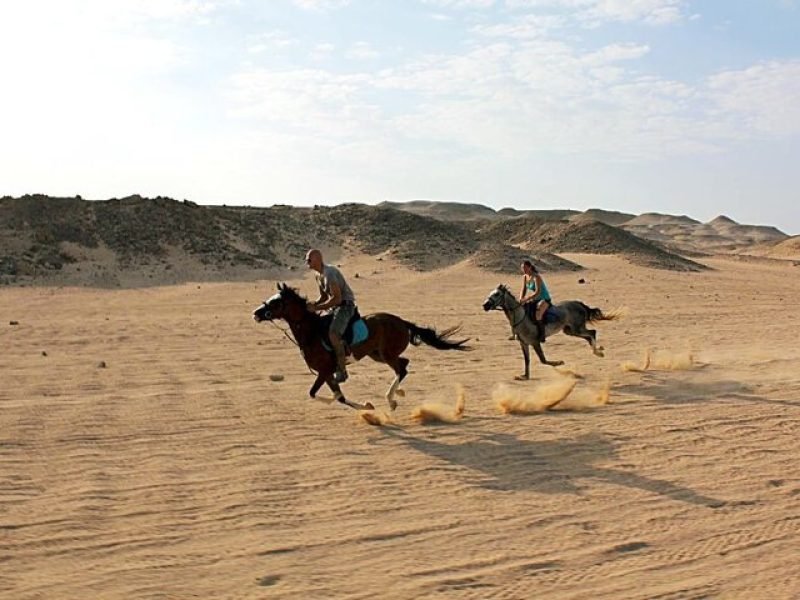 Tourist horseback riding through desert trails with a Red Sea view in Hurghada