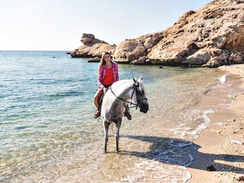 Tourist horseback riding through desert trails with a Red Sea view in Hurghada