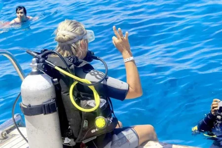 Scuba diver exploring coral reef during full-day trip with two dives in the Red Sea